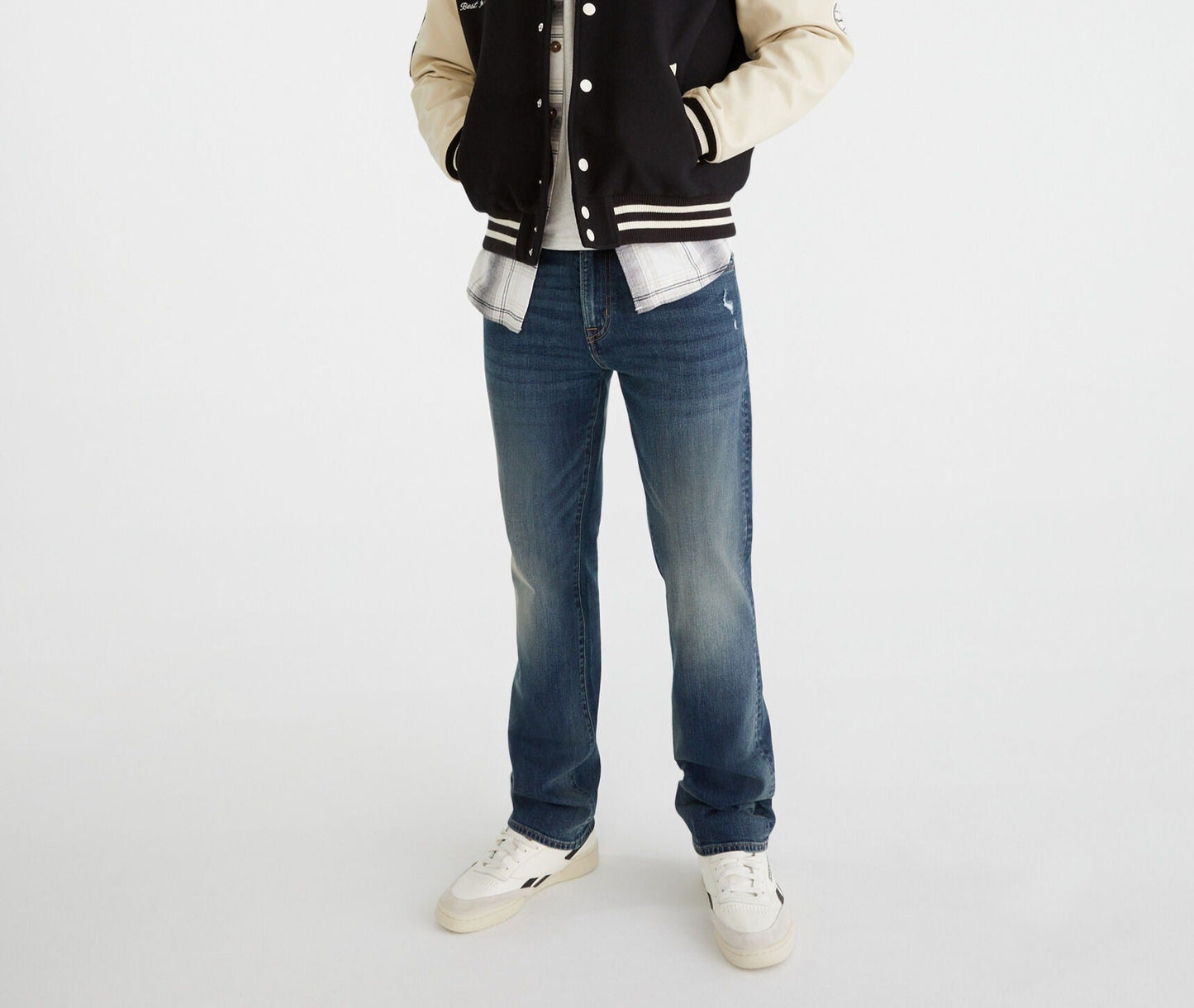 Person wearing a black and beige varsity jacket with a logo on a white background