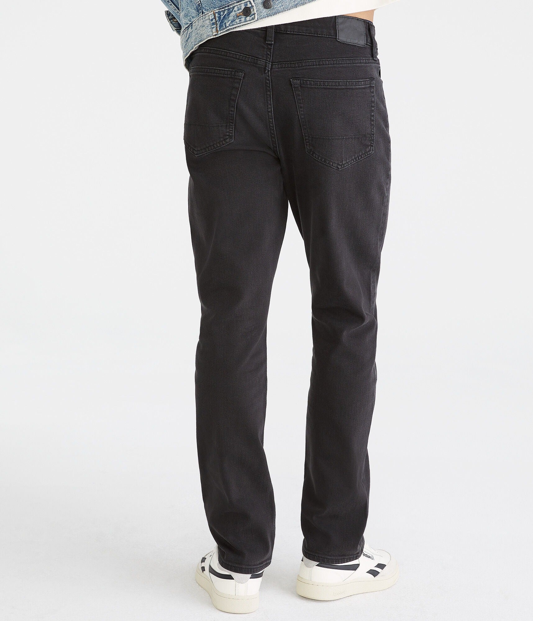 Person wearing black jeans on a white background